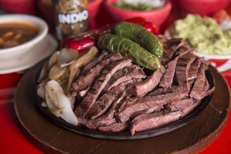 Parrillada de cortes al carbón servida en comal para compartir